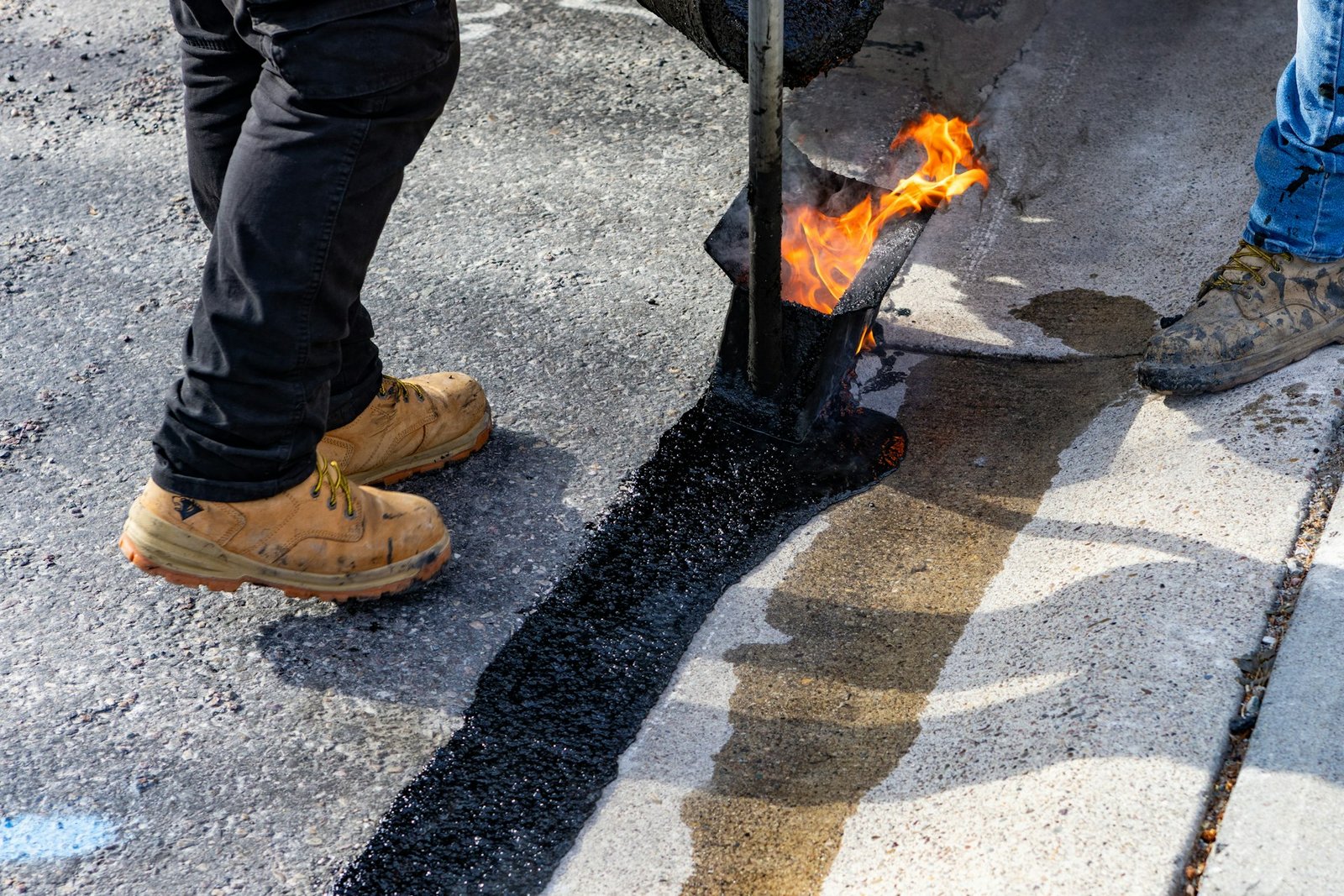 Crew applying hot asphalt for pavement repair