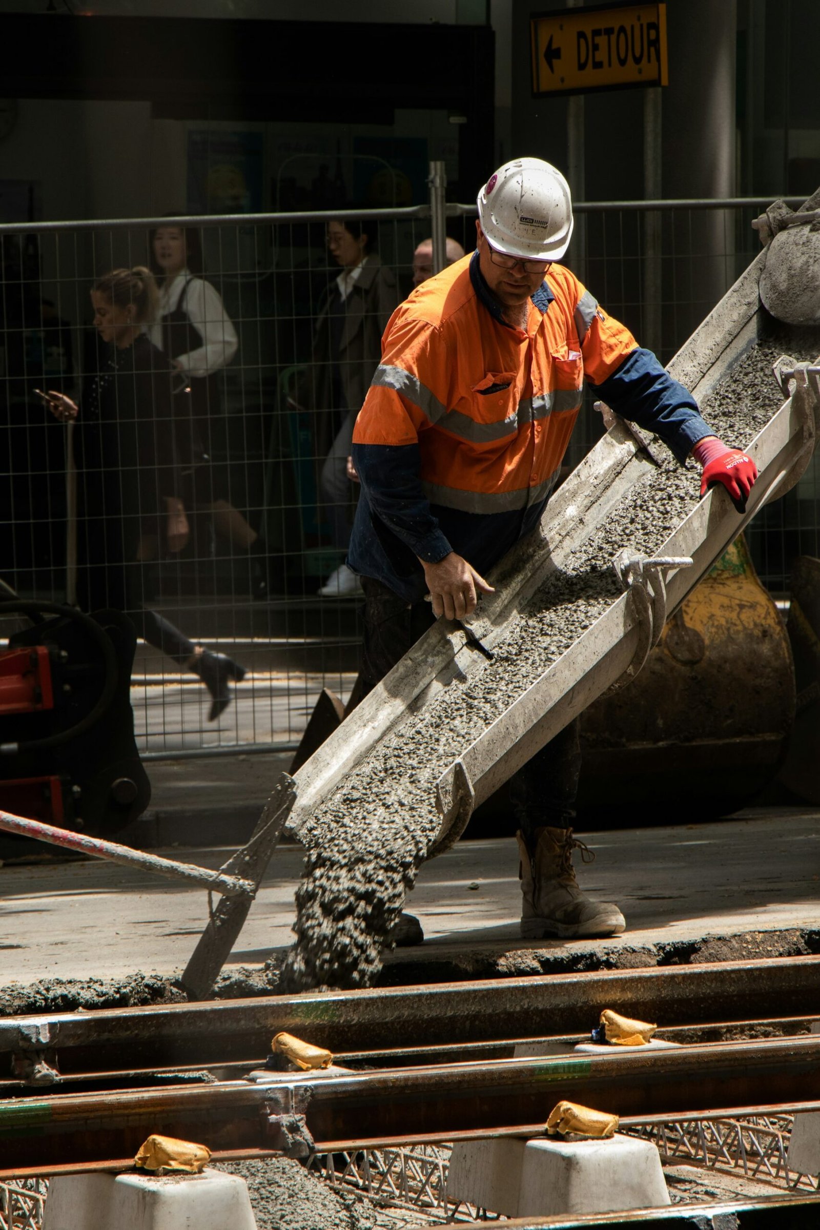 Worker pouring and finishing concrete