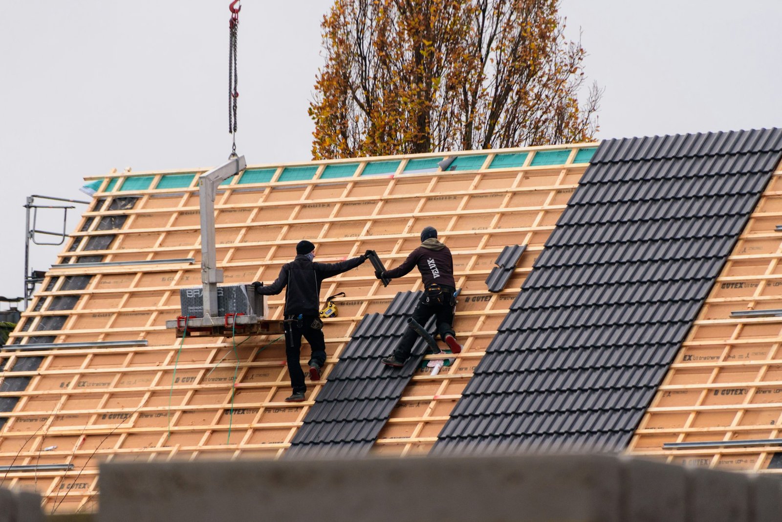 Roofing crew installing new roof system on a residential building